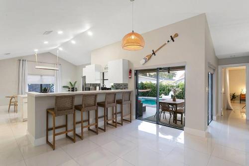 a kitchen with a bar and a dining room at Citrus+Sunshine/Heated Pool/6 min to Beach/Casino in Dania Beach