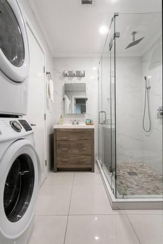 a bathroom with a washing machine and a shower at Citrus+Sunshine/Heated Pool/6 min to Beach/Casino in Dania Beach