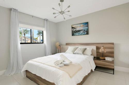 Un dormitorio blanco con una cama grande y una ventana en Citrus+Sunshine/Heated Pool/6 min to Beach/Casino, en Dania Beach
