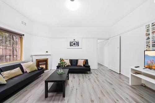 a living room with a couch and a table at Burwood new 2 bedroom 2 bathroom apartment in Sydney