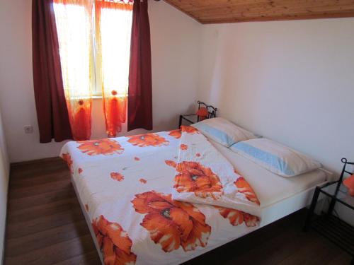 1 Schlafzimmer mit einem Bett mit Blumendecke in der Unterkunft Apartments with a parking space Kornic, Krk - 15293 in Kornić