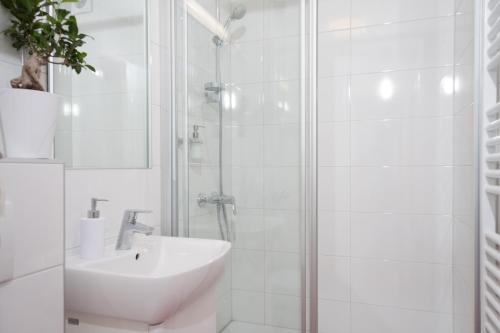 a white bathroom with a sink and a shower at Apartments with WiFi Zagreb - 15314 in Zagreb