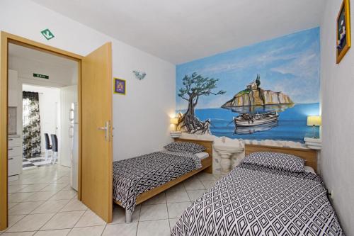 een slaapkamer met twee bedden en een schilderij aan de muur bij Holiday house with WiFi Trogir - 15319 in Trogir