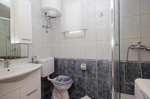 een badkamer met toilet, wastafel en douche bij Holiday house with WiFi Trogir - 15319 in Trogir