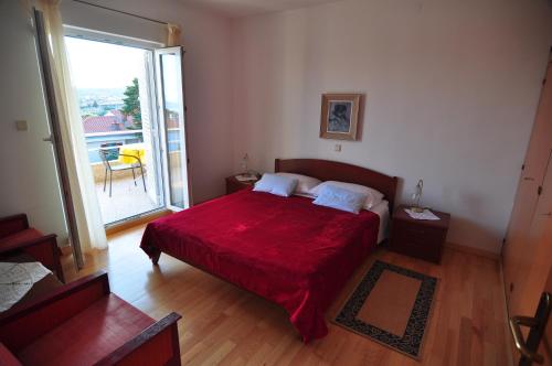 - une chambre avec un lit rouge et une grande fenêtre dans l'établissement Apartments with a parking space Krk - 15331, à Krk