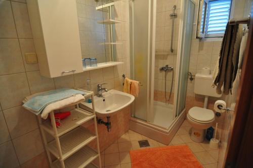 La salle de bains est pourvue d'une douche, d'un lavabo et de toilettes. dans l'établissement Apartments with a parking space Krk - 15331, à Krk