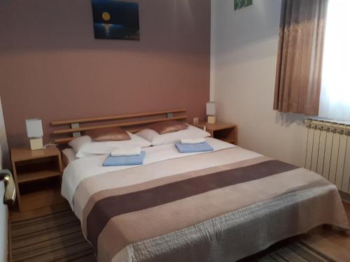 a bedroom with a large bed with two pillows at Holiday house with a parking space Poljanak, Plitvice - 15340 in Poljanak