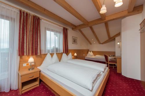 a bedroom with a large white bed in a room at Hotel Garni Hochgruber in Brunico