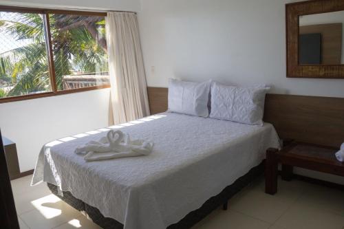 ein Schlafzimmer mit einem Bett und einem Handtuch darauf in der Unterkunft Apartamento em Barra Bali, Resort de Luxo - Destino BSM 329 in Barra de São Miguel