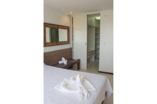 a bedroom with a bed with white towels on it at Apartamento em Barra Bali, Resort de Luxo - Destino BSM 329 in Barra de São Miguel