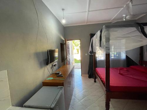 a bedroom with a bunk bed and a desk and a bed at Casa Da Luna Studios in Watamu
