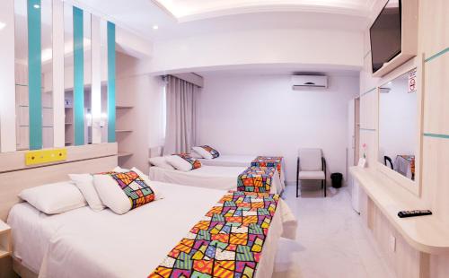 une chambre à l'hôpital avec deux lits et une fenêtre dans l'établissement Hotel Rediadri - Capão da Canoa, à Capão da Canoa