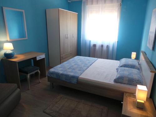 Schlafzimmer mit einem Bett, einem Schreibtisch und einem Fenster in der Unterkunft Apartments with a parking space Valbandon, Fazana - 15386 in Fažana