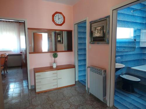 baño con lavabo y reloj en la pared en Apartments with a parking space Valbandon, Fazana - 15386, en Fažana