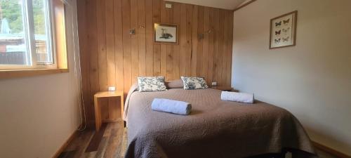 1 dormitorio con 1 cama con 2 almohadas en Posada Paso Mayer, en Villa O'Higgins