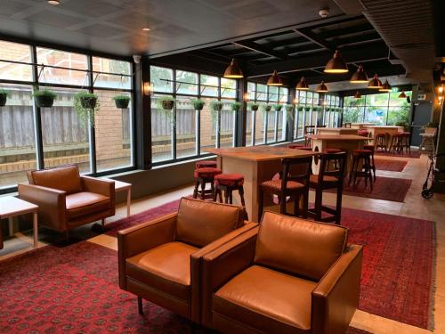 um restaurante com cadeiras e mesas de couro e janelas em Southend Hotel em Sydney