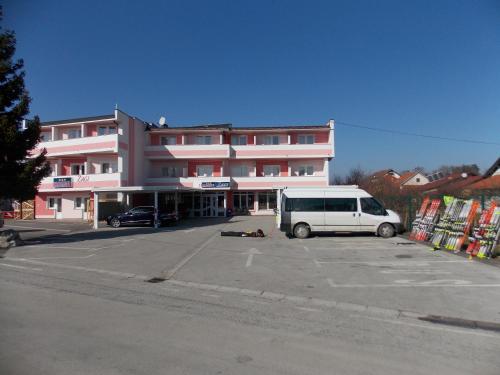 una furgoneta blanca estacionada en un estacionamiento frente a un edificio en Quadruple Room Oroslavje 15384k, en Oroslavje