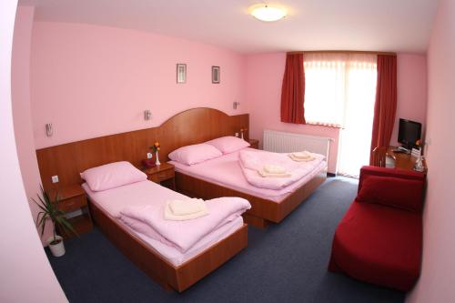a room with two beds and a red couch at Quadruple Room Oroslavje 15384k in Oroslavje