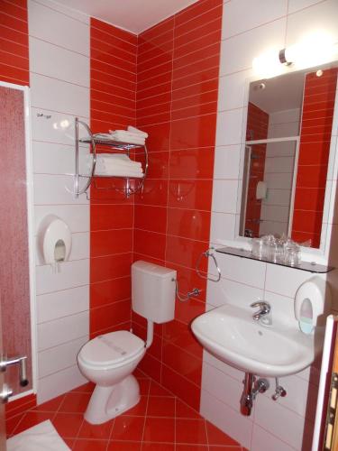 baño rojo y blanco con aseo y lavamanos en Quadruple Room Oroslavje 15384k, en Oroslavje