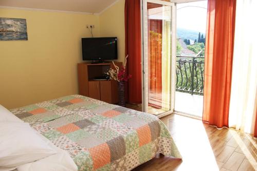 a bedroom with a bed and a balcony with a television at Apartments with WiFi Zlarin - 15409 in Zlarin