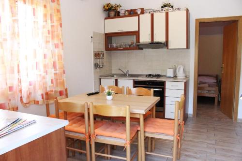 a kitchen and dining room with a table and chairs at Apartments with WiFi Zlarin - 15409 in Zlarin