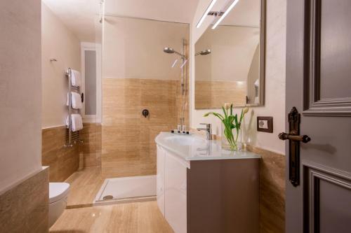 a bathroom with a white sink and a shower at Palazzo De Cupis - Suites and View in Rome