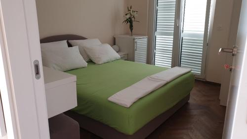 a small bedroom with a green bed in a room at Double Room Hvar 15378a in Hvar