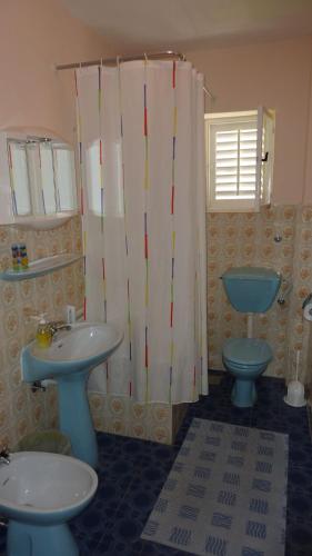 a bathroom with two sinks and a toilet and a shower at Double Room Hvar 15378a in Hvar