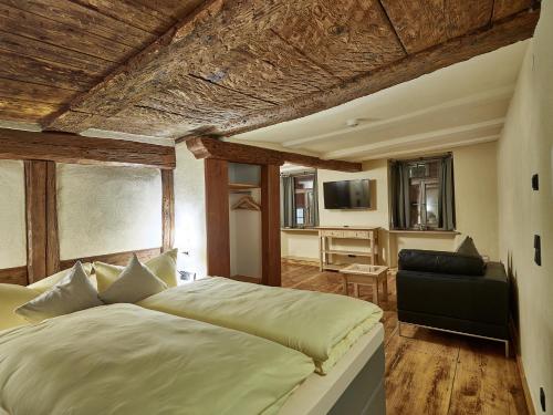 a bedroom with a large bed and a television at Am Hofbrunnen in Rothenburg ob der Tauber