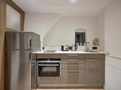 eine Küche mit einem Kühlschrank aus Edelstahl und einer Spüle in der Unterkunft Am Hofbrunnen in Rothenburg ob der Tauber
