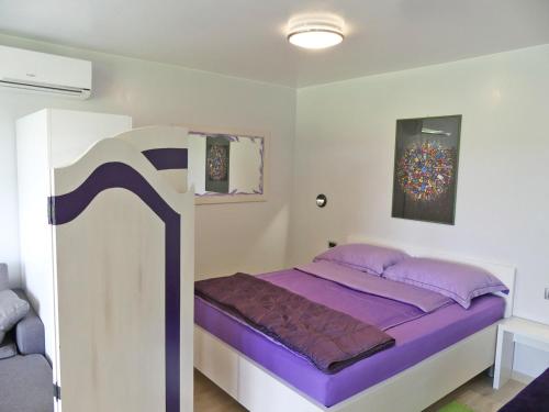 a bedroom with a bed with purple sheets at Apartments with WiFi Zagreb - 15474 in Zagreb