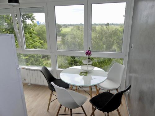 a white table and chairs in a room with windows at Apartments with WiFi Zagreb - 15474 in Zagreb