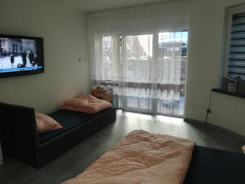 een woonkamer met 2 bedden en een flatscreen-tv bij Viktoria in Ełk