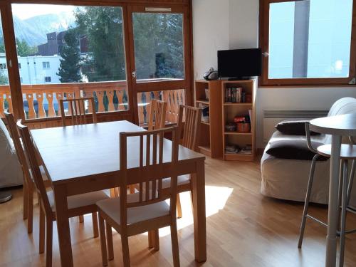 un salon avec une table, des chaises et un canapé dans l'établissement Les Deux Alpes - Appartement 2 pièces, 6 personnes, 42m², au pied des pistes avec garage privatif - FR-1-516-182, à Les Deux Alpes