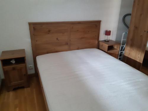 een slaapkamer met een wit bed en een houten hoofdeinde bij Appartement Les Deux Alpes, 2 pièces, 6 personnes - FR-1-516-182 in Les Deux Alpes
