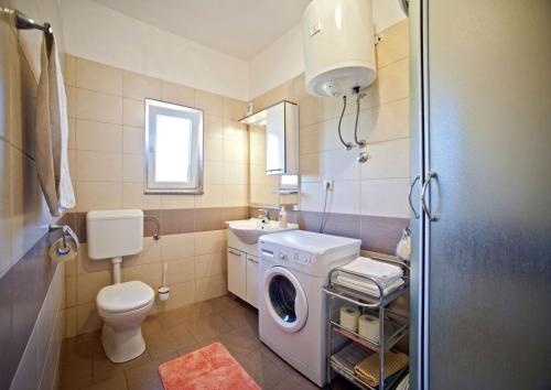 a bathroom with a washing machine and a washer at Apartments with a parking space Gornje selo, Solta - 15545 in Grohote