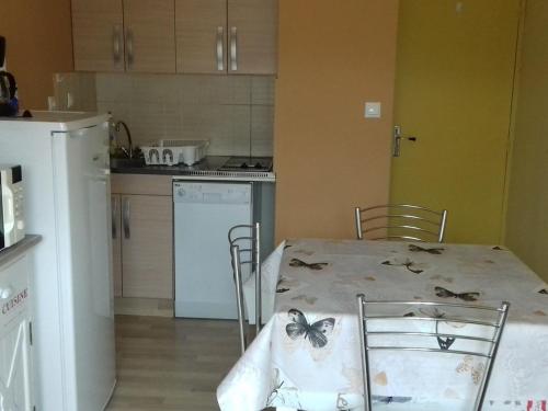 - une cuisine avec une table et un papillon dans l'établissement Studio cabine 4 pers, tout équipé au cœur de la station - FR-1-592-44, à Bolquère-Pyrénées 2000