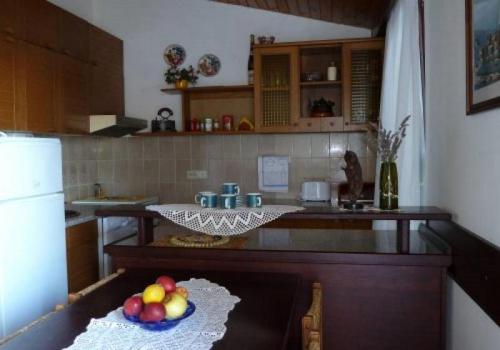 una cocina con una mesa con un bol de fruta. en Apartments by the sea Kaprije - 15567, en Kaprije