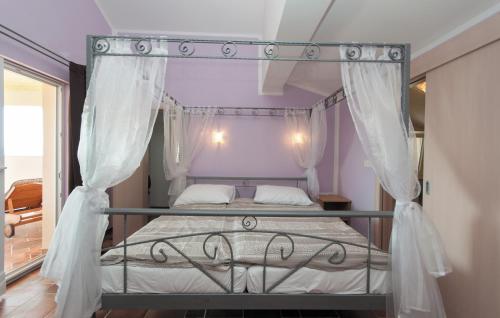a bedroom with a canopy bed with white curtains at Luxury villa with a swimming pool Supetarska Draga - Gonar, Rab - 15575 in Rab