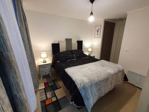 ein Schlafzimmer mit einem Bett und zwei Lampen in der Unterkunft Bello depto en Dunas de Concon in Concón