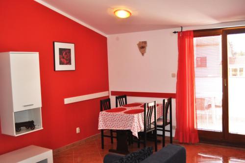 ein Esszimmer mit roten Wänden und einem Tisch mit Stühlen in der Unterkunft Apartments with a parking space Pula - 15582 in Pula