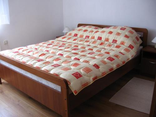 a bed with a quilt on it in a bedroom at Apartments with a parking space Delnice, Gorski kotar - 15589 in Delnice