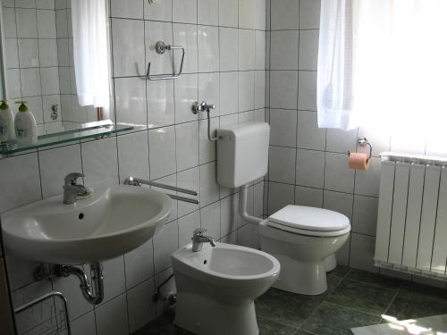 a white bathroom with a sink and a toilet at Apartments with a parking space Delnice, Gorski kotar - 15589 in Delnice