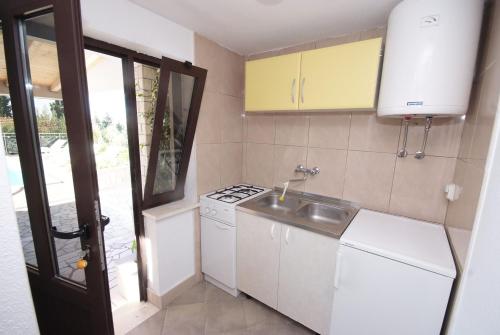 uma pequena cozinha com um lavatório e um fogão em Family friendly apartments with a swimming pool Trpanj, Peljesac - 15603 em Trpanj