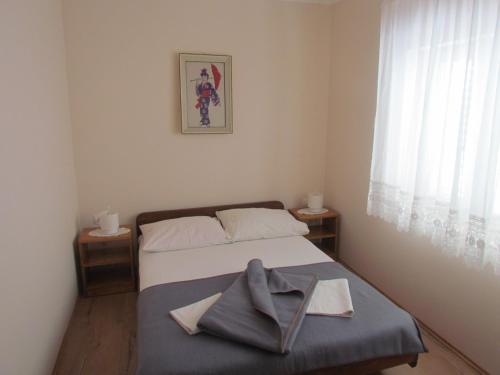 um quarto com uma cama com uma toalha em Family friendly apartments with a swimming pool Trpanj, Peljesac - 15603 em Trpanj