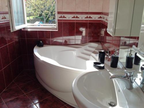 a bathroom with a white tub and a sink at Apartments with a parking space Risika, Krk - 15609 in Vrbnik