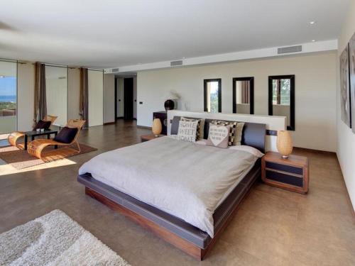 エステポナにあるContemporary Villa, Golf La Alquería, Benahavis, Marbellaのベッドルーム(大型ベッド1台付)、リビングルームが備わります。