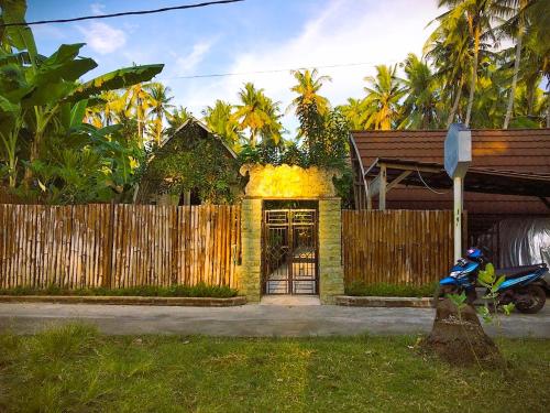 une maison avec un portail en face d'une clôture dans l'établissement The Vagary Vibes, à Nusa Penida