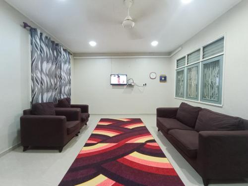 a living room with two couches and a tv at Homestay Sejati in Kuala Berang