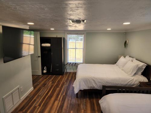 a bedroom with two beds and wooden floors and a room at Cozy Hideaway in the Duck Pond area of Gainesville in Gainesville